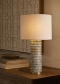 Table lamp with textured base on a wooden surface, soft lighting
